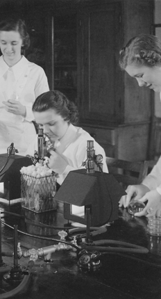 Women working in science with microscopes on the table